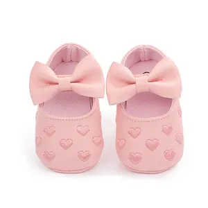 Detailansicht von rosa Baby-Prinzessinenschuhen mit Herzstickerei und einer Schleife
