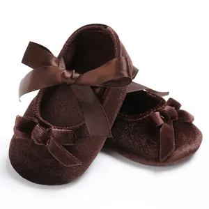 Vue détaillée et rapprochée de chaussures bébé en velours avec nœuds en satin.