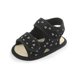 Close-up detail of black fabric baby walker sandals featuring white triangle pattern design