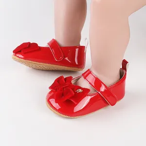 Λεπτομέρεια κόκκινα βρεφικά παπούτσια από λουστρίνι με βελούδινο φιόγκο και βέλκρο
