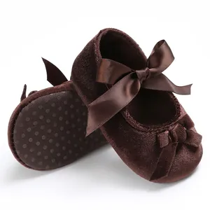 Vue détaillée des chaussures bébé en velours marron avec ruban et semelle souple