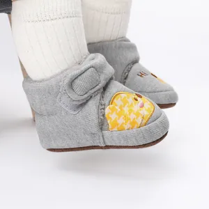 Nahaufnahme von grauen Baby-Winterschuhen mit gelbem Küken-Design und weichem Strickgewebe