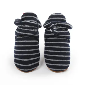 Détail de chaussons d'hiver rayés pour bébé avec doublure en peluche douce et chaleureuse