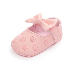 Detail von rosa Baby-Prinzessin-Schuhen mit Schleife und Herzbestickung
