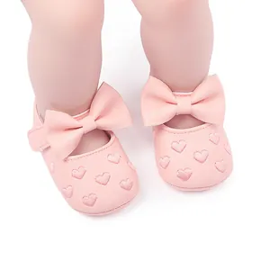 Detail view of pink baby princess walker shoes with bow and embroidered hearts
