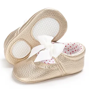 Vista detallada de zapatos de princesa dorados para bebé con lazo y suela flexible