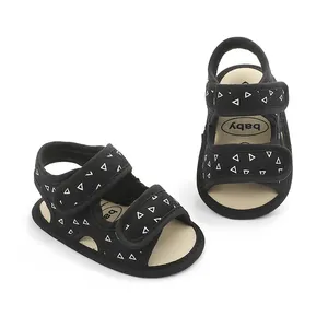 Detailed view of black baby sandals with soft anti-slip soles and triangle pattern.