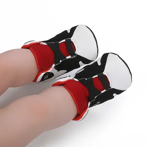 Close-up detail of red and black baby basketball sneakers with soft anti-slip soles