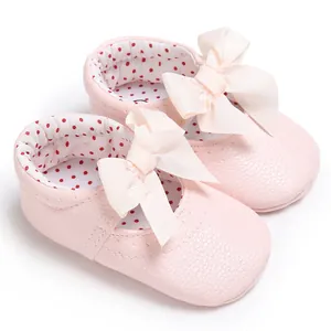 Vista detallada de zapatos de princesa rosa para bebé con lazos y forro de lunares