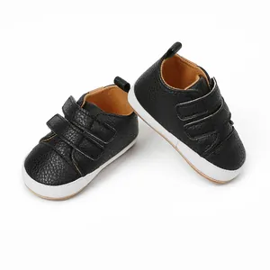 Macro view of black textured faux leather baby walking shoes with dual velcro straps