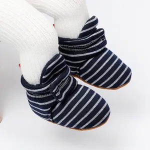 Détail de chaussons d'hiver rayés pour bébé avec doublure polaire et semelle souple