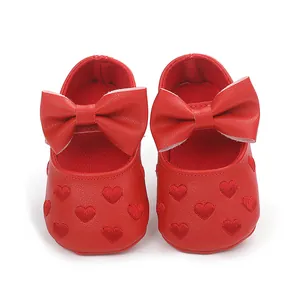 Detailansicht roter Baby-Prinzessin-Schuhe mit Schleifendekor und Herzbestickung