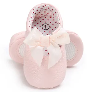 Vista detallada de zapato rosa de princesa para bebé con lazo color crema