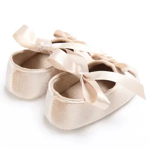 Détail de chaussures souples pour bébés avec de grands nœuds élégants en ruban de soie.
