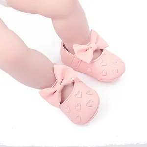 Detailansicht von rosa Baby-Prinzessin-Schuhen mit Schleifen und Herzen.