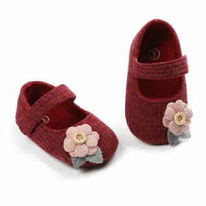 Detailansicht roter Cord-Babyschuhe für Mädchen mit dekorativer rosa Strickblume