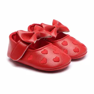 Close-up of red baby princess walker shoes with heart embroidery and bow detail