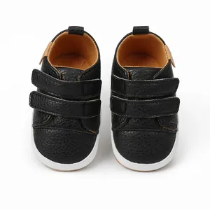 Detailed overhead view of black faux leather infant walking shoes with double velcro straps