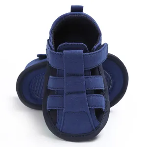 Close-up of navy blue closed-toe baby sandals with soft, anti-slip soles for boys.