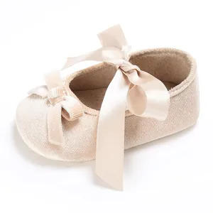 Vue détaillée de chaussure bébé champagne avec ruban satiné, texture velours et noeud