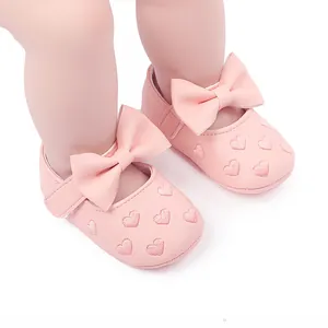 Nahaufnahme von rosa Baby-Prinzessin-Schuhen mit Herzbestickung und Schleife