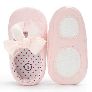 Vista detallada de zapatos de princesa rosa para bebé con lazo y forro de lunares