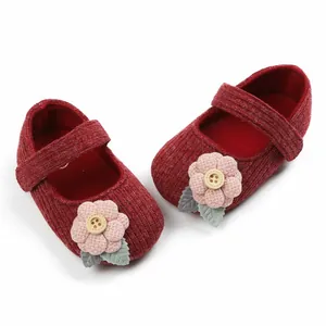 Detailaufnahme der roten Baby-Prinzessinenschuhe mit weicher rosa Blumendekoration