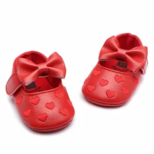 Detailed view of red faux leather baby princess shoes with bow and heart pattern