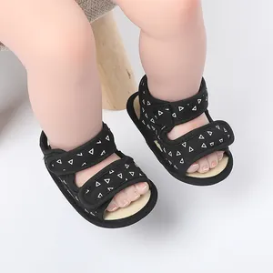 Close-up of black baby summer sandals with white triangle print and soft sole