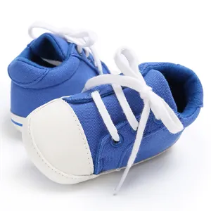 Nahaufnahme von blauen Baby-Leinenschuhen mit weißer Gummikappe und Schnürsenkeln.