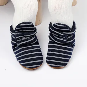 Détail de bottines de marche pour bébé à rayures bleu marine avec fermeture velcro.