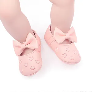 Detailansicht von rosa Baby-Prinzessinnen-Lauflernschuhen mit Schleife und Herzstickerei.