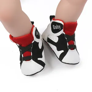 Detail of baby basketball sneakers with red, white and black panels on soft sole