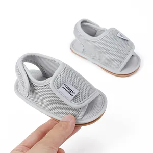 Nahaufnahme grauer atmungsaktiver Baby-Lauflernschuhe mit praktischem Klettverschluss