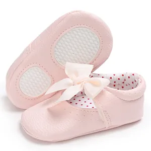 Primer plano detallado de zapatos de princesa rosas para bebé con un lazo decorativo