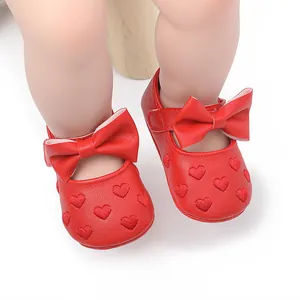 Detailansicht von roten Baby-Prinzessin-Schuhen mit Herzstickerei und schöner Schleife