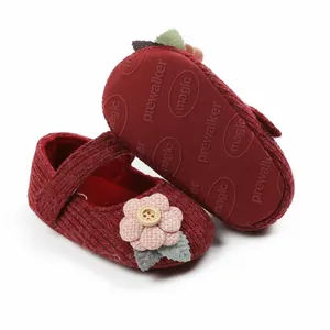 Nahaufnahme von dunkelroten Baby-Prinzessin-Schuhen mit Blume und weicher Sohle