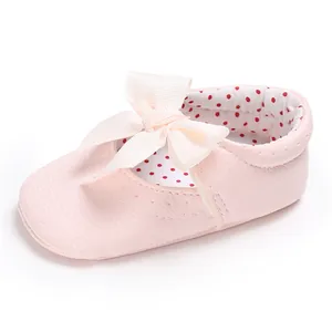 Vista detallada de zapato rosa para bebé con lazo crema y forro interior de lunares