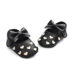 Detailansicht schwarzer Baby-Prinzessinnen-Lauflernschuhe mit Herzstickerei und Schleife.