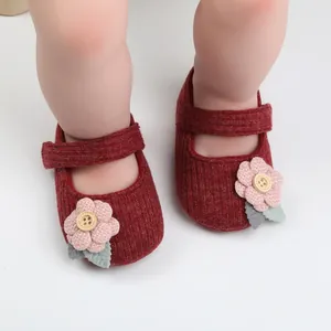 Detailansicht der roten gestrickten Baby-Mary-Janes für Mädchen mit rosa Stoffblume