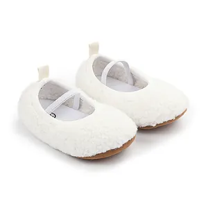Close-up detail of white fuzzy sherpa baby walking shoes with elastic strap and brown sole