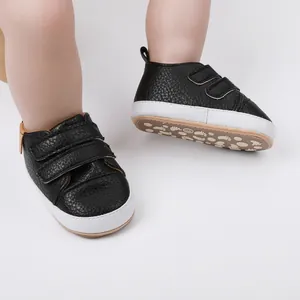 Black pebble-grain infant walking shoes with soft white soles and velcro straps
