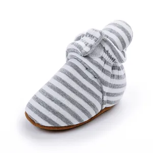 Détail des chaussons pour bébé à rayures grises et blanches avec doublure en polaire