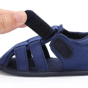 Close-up view of navy blue baby boy closed-toe sandal showing adjustable Velcro strap