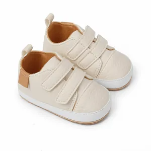 Detailed macro view of beige infant walking sneakers with double hook-and-loop straps.