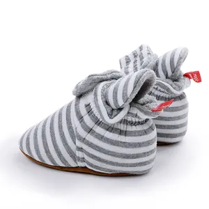 Bottes d'hiver pour bébé à rayures gris et blanc avec doublure polaire et cheville élastique.