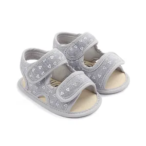 Detail view of gray baby walking sandals with white triangle patterns and soft soles