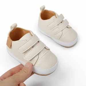 Detail view of cream-colored soft-sole baby shoes showing velcro straps and stitching