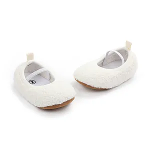 Close-up of white fleece baby walking shoes with elastic strap and brown sole