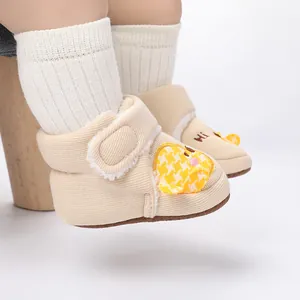 Nahaufnahme beige Baby Winterschuhe mit süßem gelben Kükendesign und Stickerei